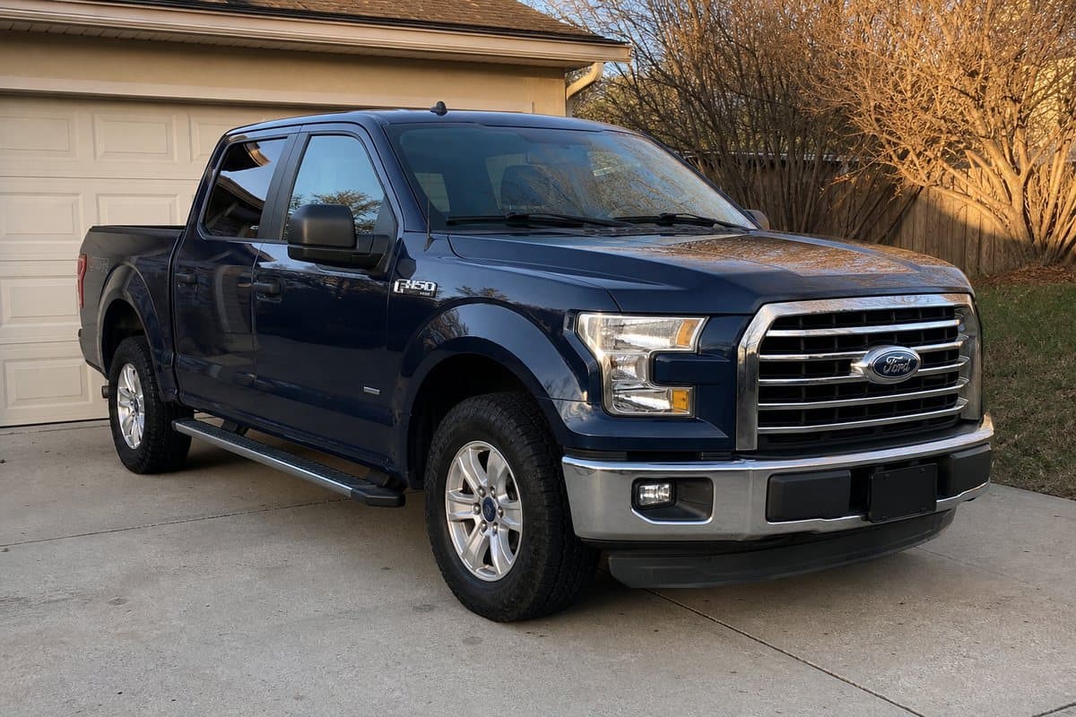 A dark blue Ford F-150 in a driveway